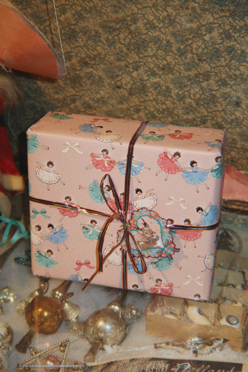 Christmas gift in pink ballerina wrapping paper with a striped ribbon